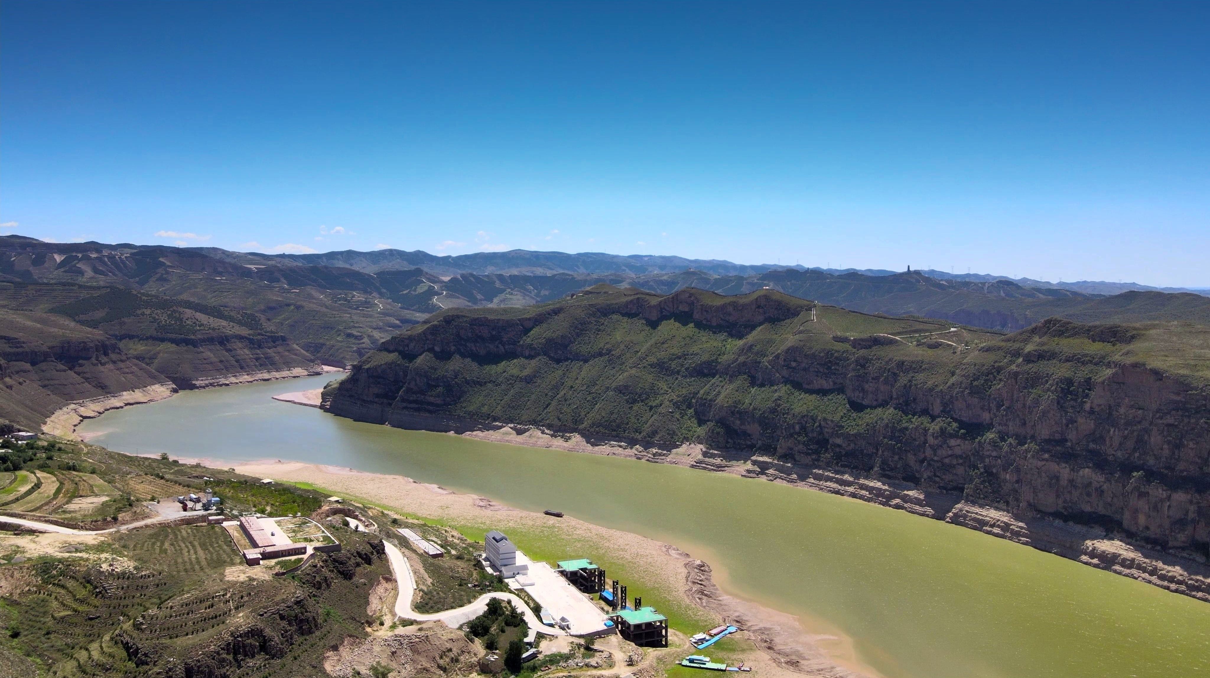 The Yellow River winding through the loess canyon at Laoniuwan, with a village on the bank