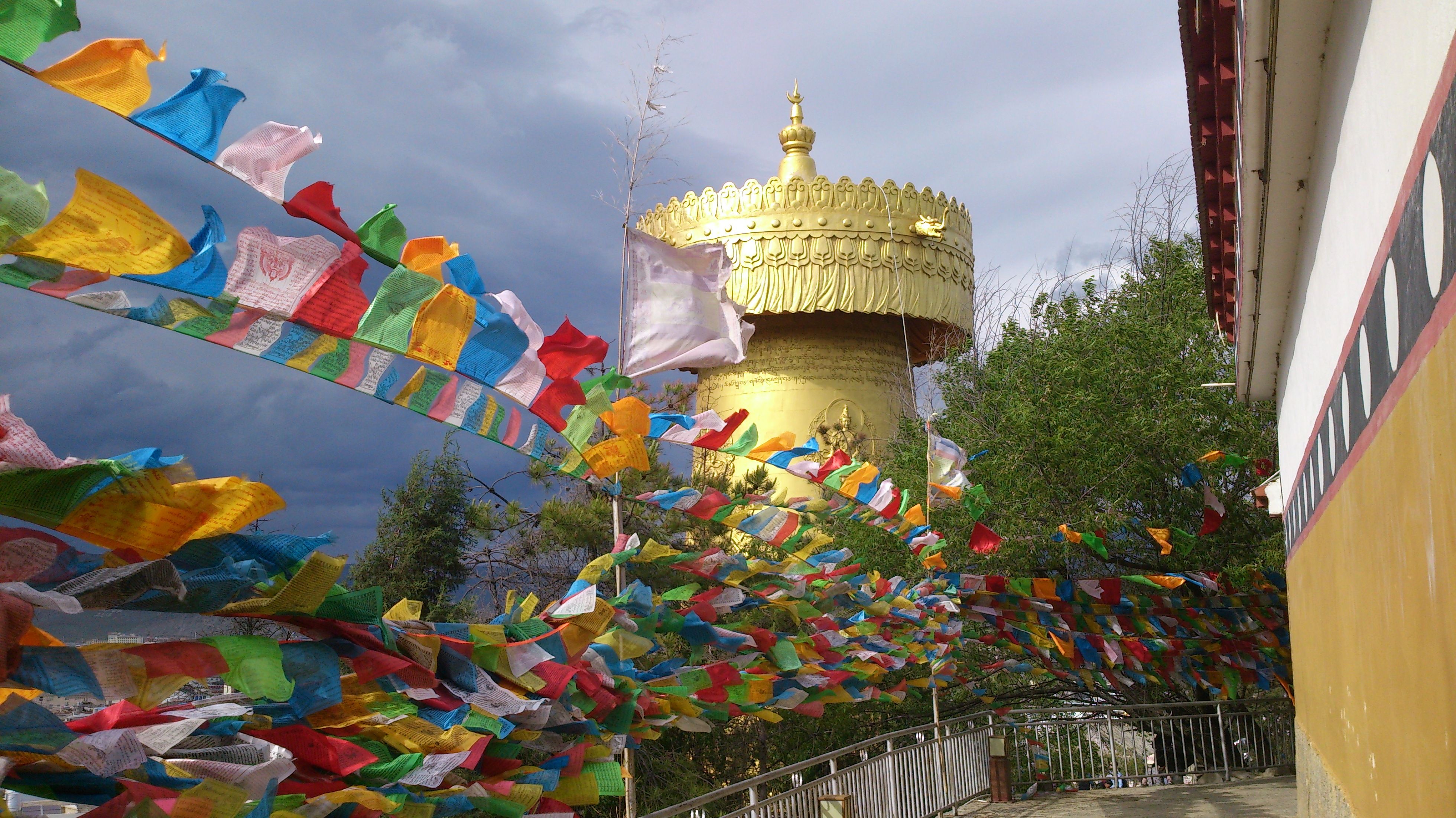 The giant golden prayer wheel above Shangri-La's old town, with strings of prayer flags