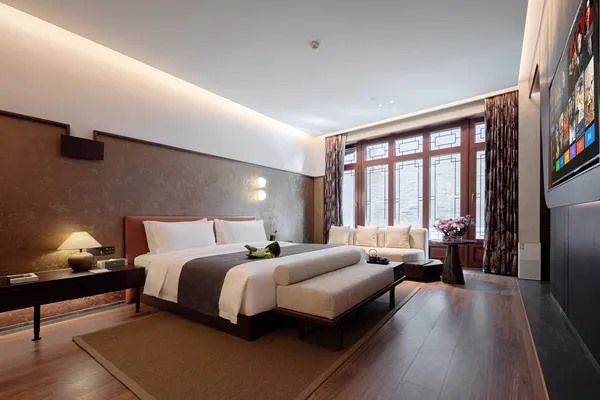 A room at Bo Yuan'er: a wide bed, wooden floor and tall lattice windows onto the courtyard