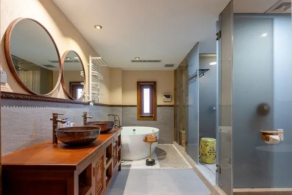 A Gaogongfu bathroom: two copper basins under round mirrors and a freestanding bathtub
