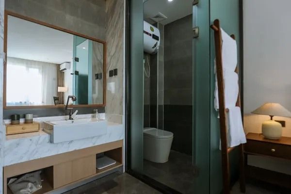 The bathroom at Yellow River Qiankun B&B: a marble basin and a glass shower