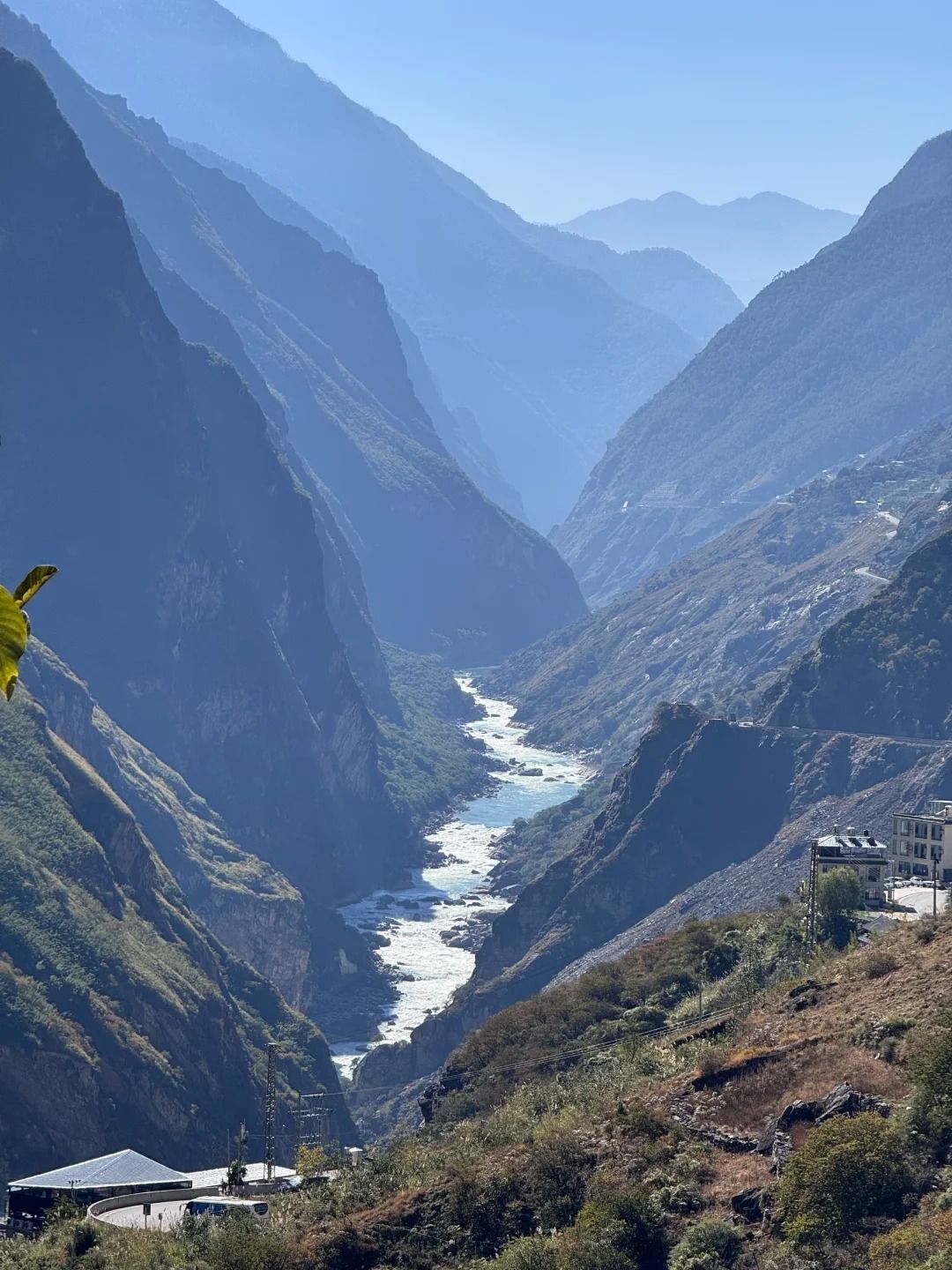 Tiger Leaping Gorge in blue morning haze, the white river far below between the mountain walls