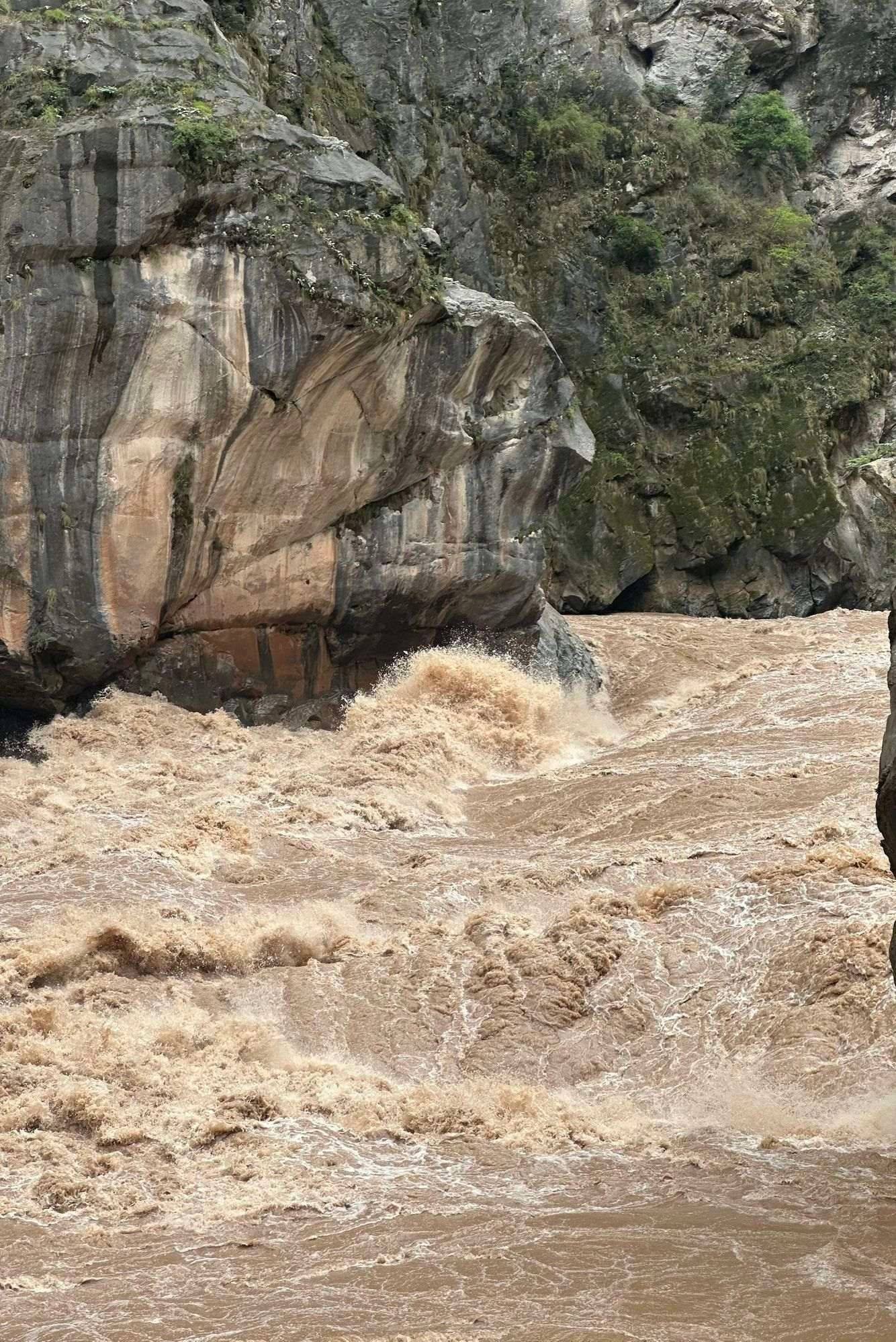 Le Jinsha, brun en saison des pluies, se fracasse contre un rocher dans les gorges du milieu